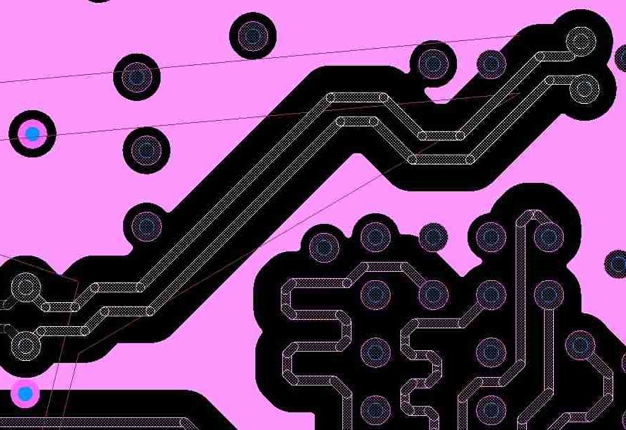 A differential pair routed symmetrically around an obstacle on a PCB